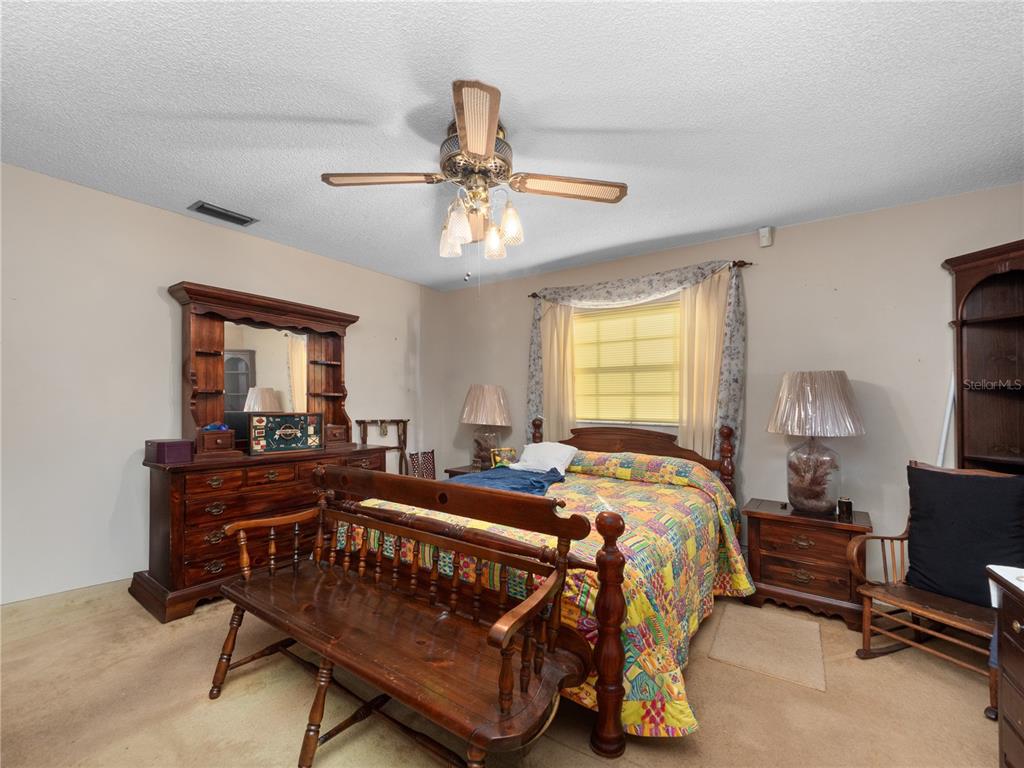 6604 Mt Plymouth Road Apopka, FL 32712 - Photo 15 of 31 a bed room with a bed and a chandelier