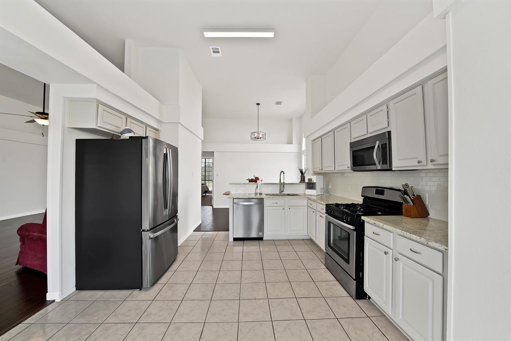 5418 Highgate Lane Rowlett, TX 75088 - Photo 14 of 36 a kitchen with granite countertop a refrigerator and a sink