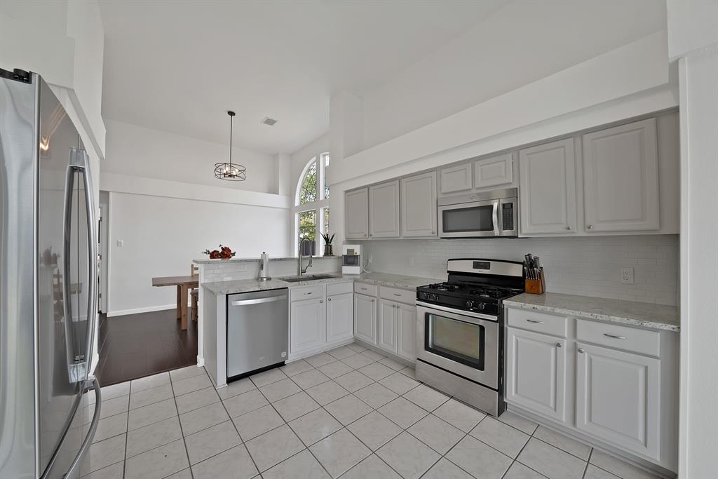 5418 Highgate Lane Rowlett, TX 75088 - Photo 15 of 36 a kitchen with white cabinets stainless steel appliances and sink