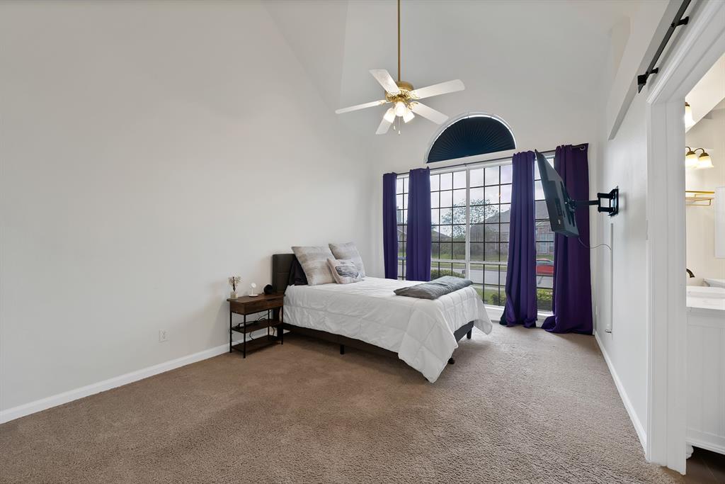 5418 Highgate Lane Rowlett, TX 75088 - Photo 18 of 36 a spacious bedroom with a bed and window