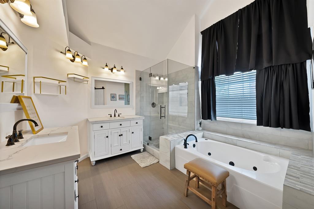 5418 Highgate Lane Rowlett, TX 75088 - Photo 21 of 36 a bathroom with a tub sink double vanity granite tub and shower