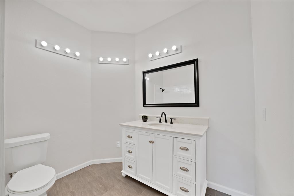 5418 Highgate Lane Rowlett, TX 75088 - Photo 24 of 36 a bathroom with a toilet sink double vanity and mirror