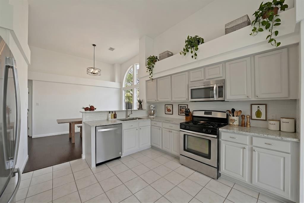 5418 Highgate Lane Rowlett, TX 75088 - Photo 5 of 36 a kitchen with stainless steel appliances granite countertop a sink a stove a refrigerator and cabinets