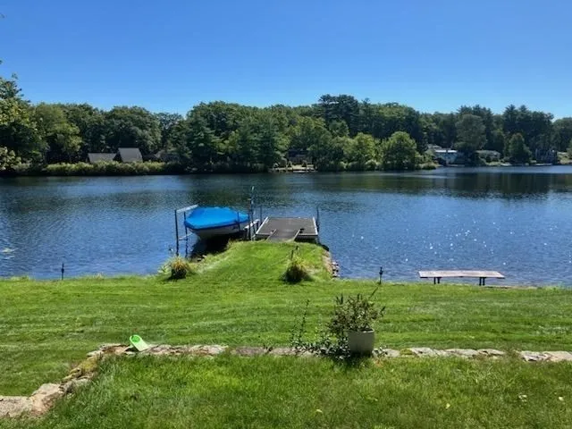 a backyard of a house with lots of green space and lake view