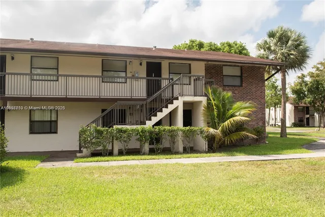 a front view of house with yard and trees in the background
