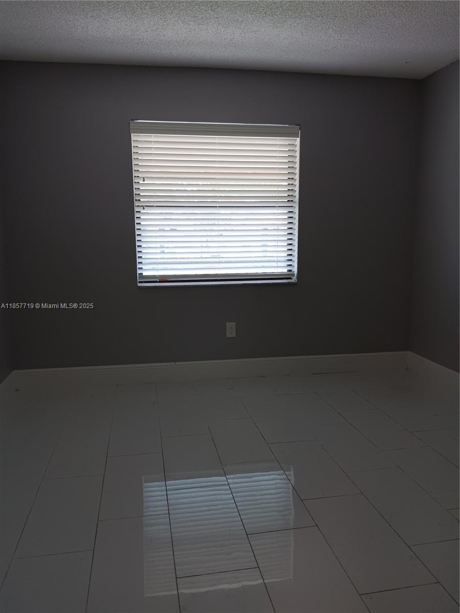 6040 Shaker Wood Circle, Unit 208 Tamarac, FL 33319 - Photo 19 of 25 a view of an empty room with a window