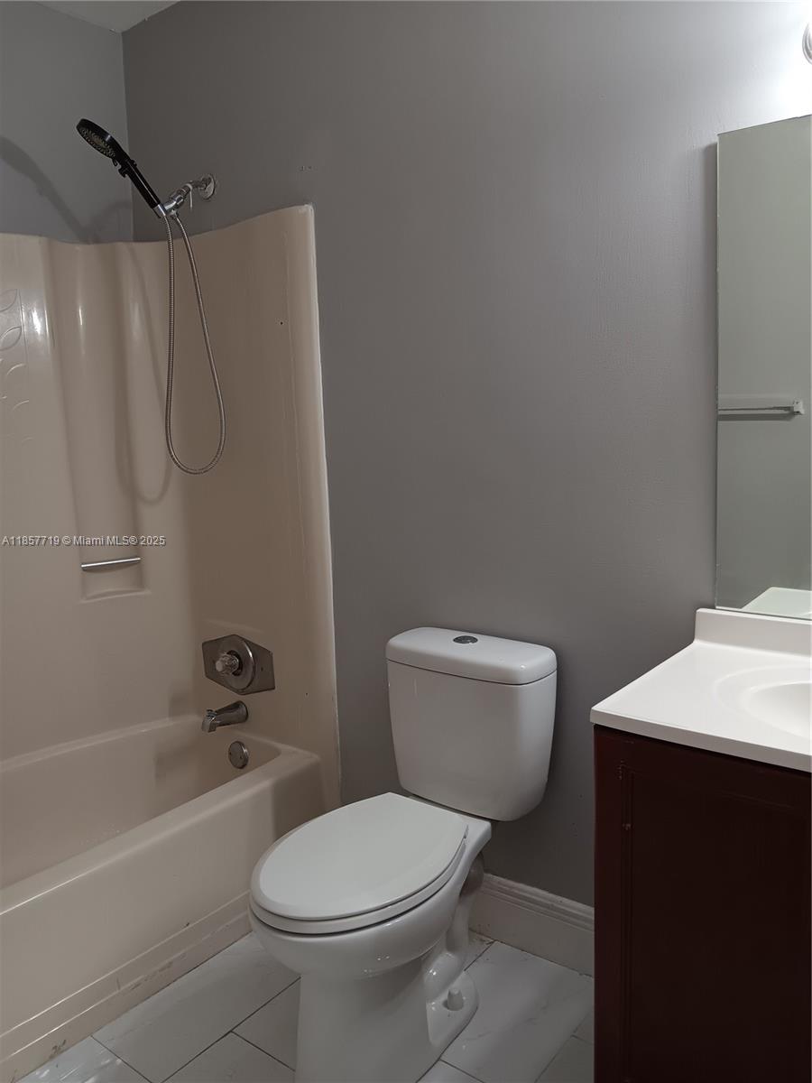 6040 Shaker Wood Circle, Unit 208 Tamarac, FL 33319 - Photo 24 of 25 a bathroom with a toilet and shower