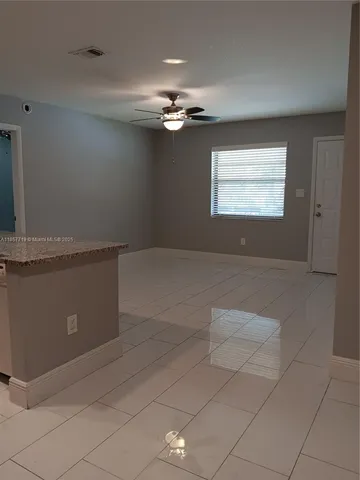 a view of a livingroom with a ceiling fan and window