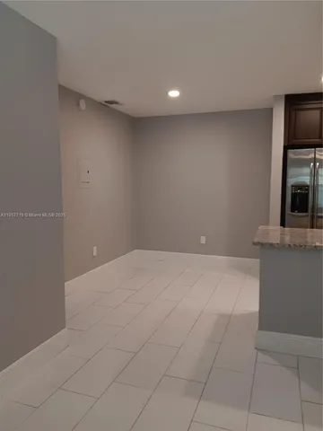 a view of an empty room with a fireplace and a window