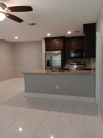 a large kitchen with stainless steel appliances a large counter top