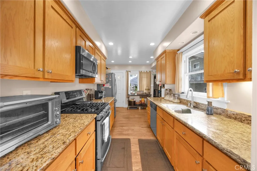 7612 Pickering Avenue Whittier, CA 90602 - Photo 15 of 53 a large kitchen with stainless steel appliances granite countertop a lot of counter space and a sink