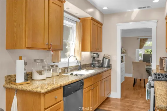 a kitchen with sink a refrigerator and wooden cabinets