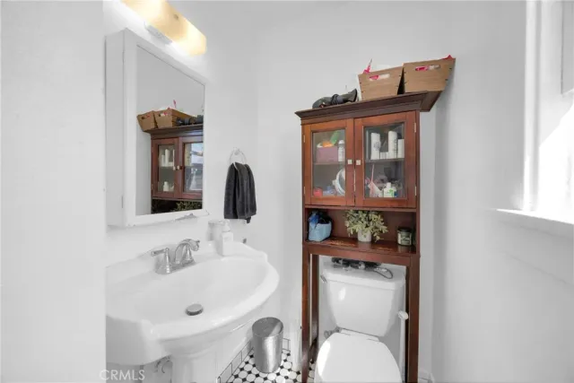 a bathroom with a sink and mirror with toilet