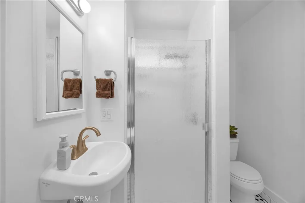 7612 Pickering Avenue Whittier, CA 90602 - Photo 23 of 53 a bathroom with a sink and mirror with toilet