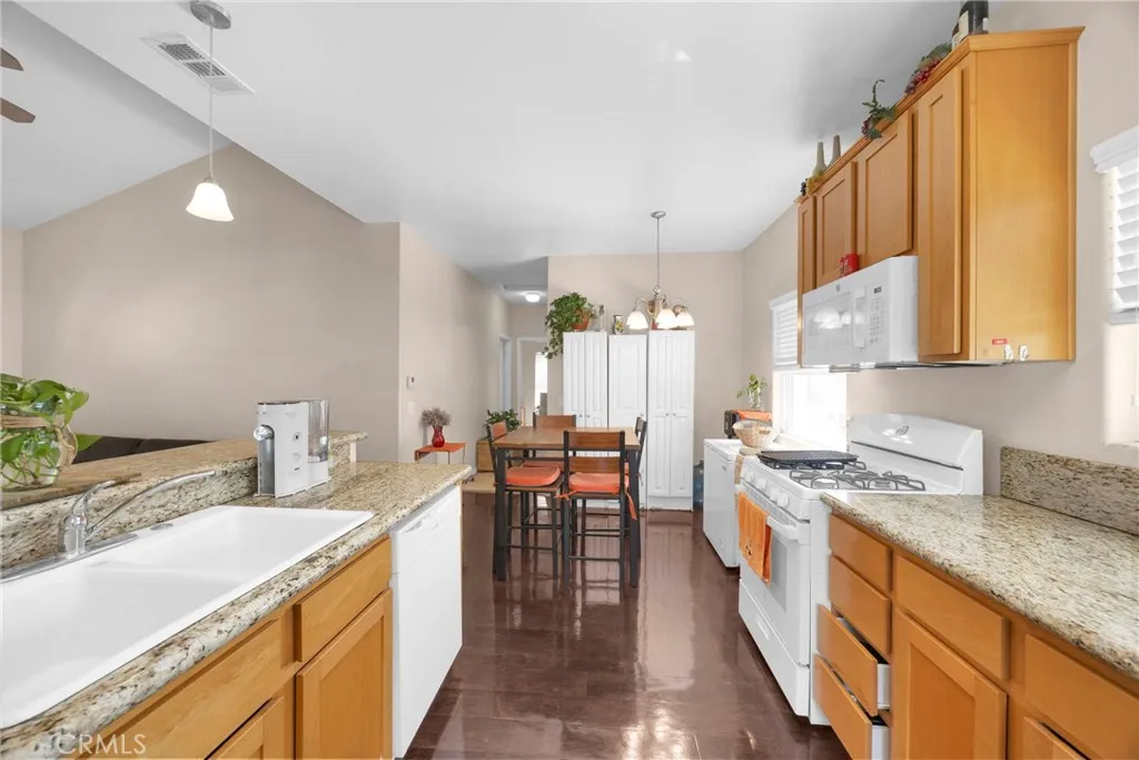 7612 Pickering Avenue Whittier, CA 90602 - Photo 38 of 53 a kitchen with a stove top oven a sink a dining table and chairs