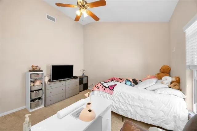 a spacious bedroom with a bed and a flat screen tv