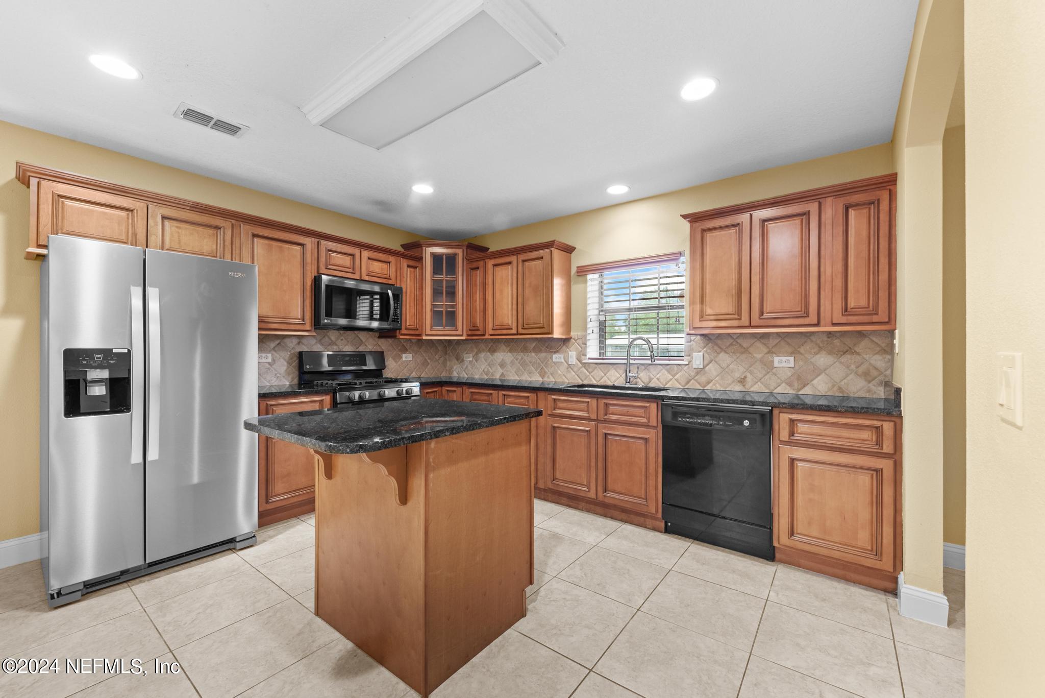 218 Lily Road St. Augustine, FL 32086 - Photo 7 of 28 a kitchen with stainless steel appliances granite countertop a refrigerator and a stove top oven