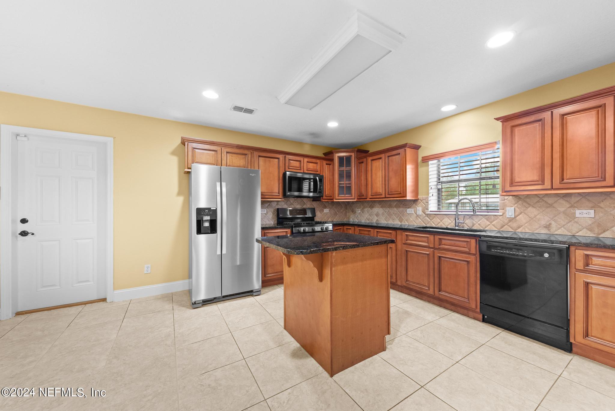 218 Lily Road St. Augustine, FL 32086 - Photo 10 of 28 a kitchen with stainless steel appliances granite countertop a refrigerator and a stove top oven