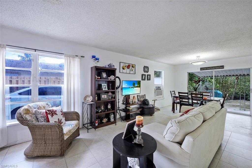 3400 Canal Street Naples, FL 34112 - Photo 1 of 32 a living room with furniture and a bookshelf
