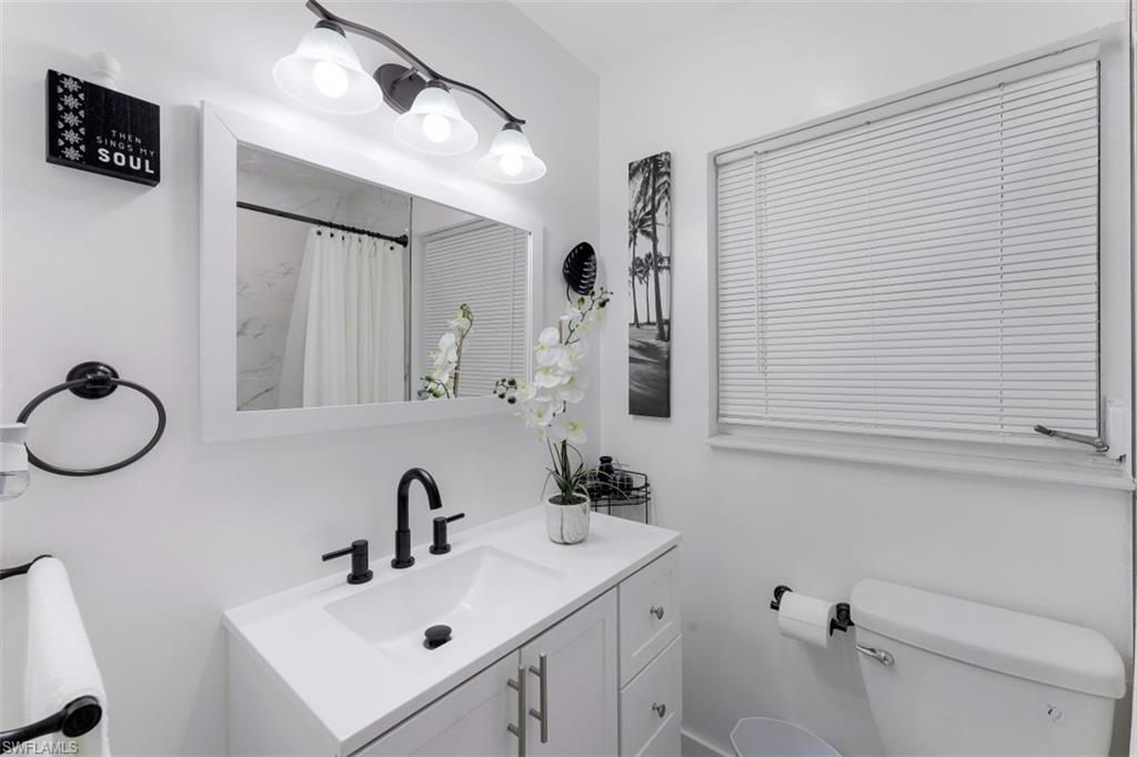 3400 Canal Street Naples, FL 34112 - Photo 11 of 32 a bathroom with a sink vanity mirror and toilet