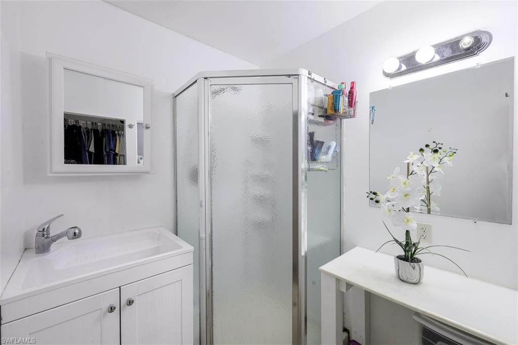 3400 Canal Street Naples, FL 34112 - Photo 13 of 32 a bathroom with a sink a mirror and a shower