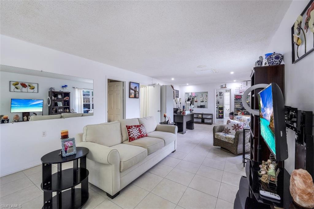 3400 Canal Street Naples, FL 34112 - Photo 2 of 32 a living room with furniture and a flat screen tv