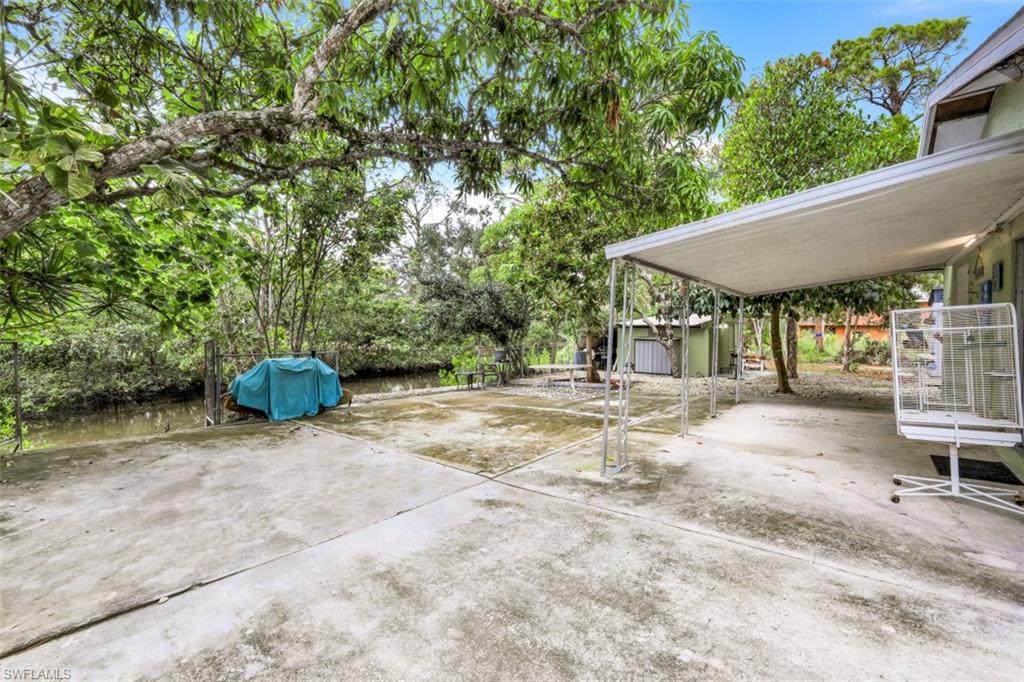 3400 Canal Street Naples, FL 34112 - Photo 22 of 32 a view of a patio with table and chairs under an umbrella