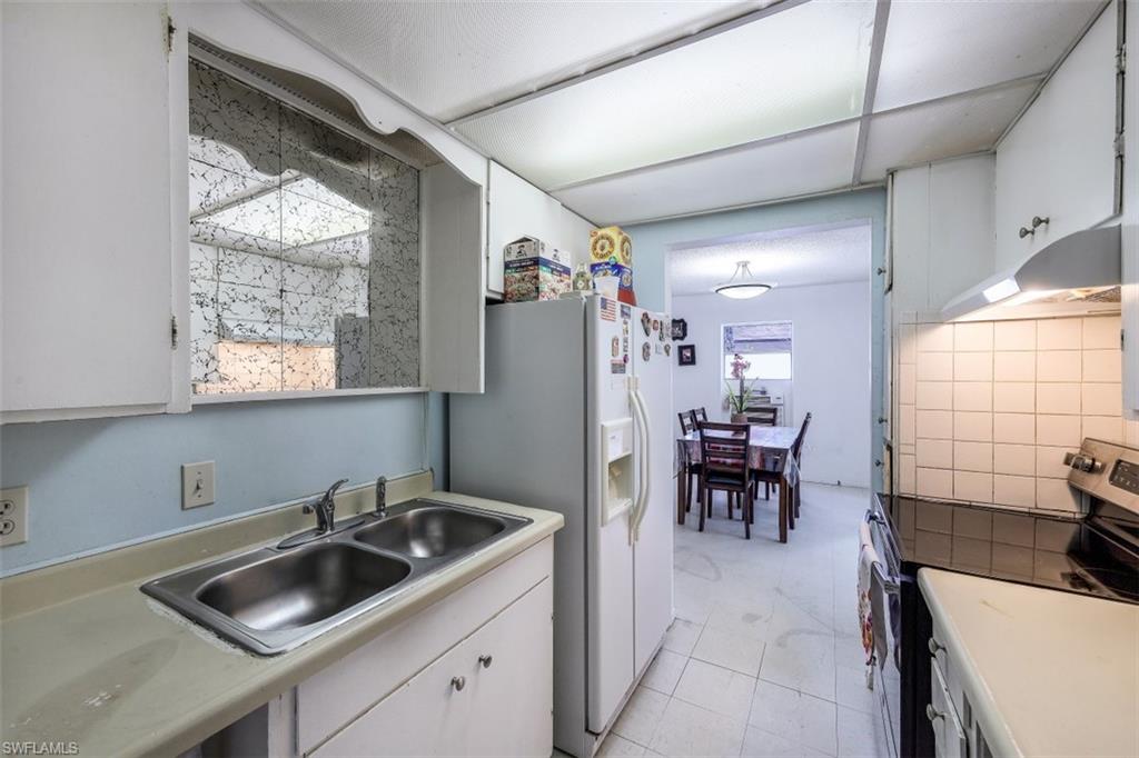 3400 Canal Street Naples, FL 34112 - Photo 6 of 32 a kitchen that has a sink and a table in it