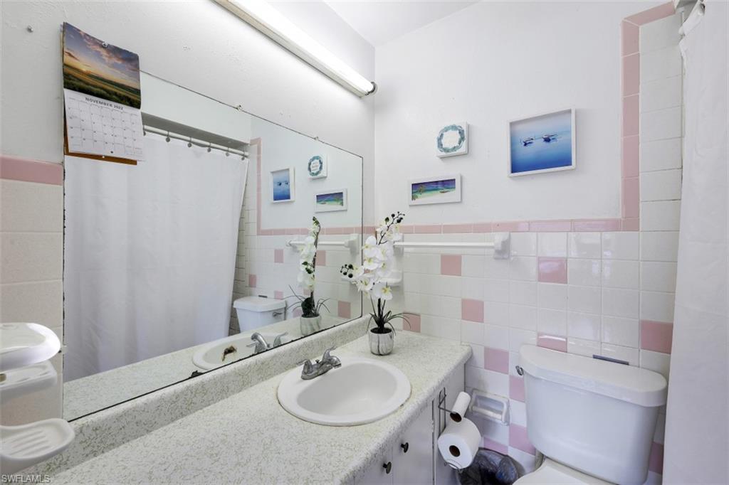 3400 Canal Street Naples, FL 34112 - Photo 9 of 32 a bathroom with a sink toilet vanity and shower