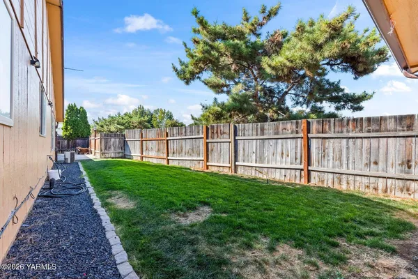 a view of a yard with wooden fence