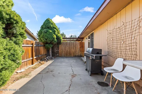 a backyard of a house with table and chairs