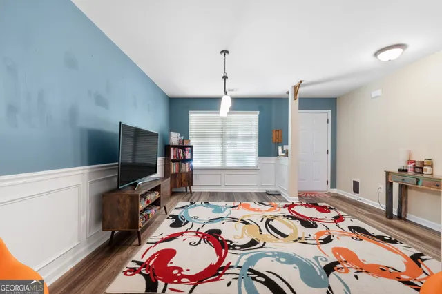 a bedroom with bed and a flat tv screen on the dresser