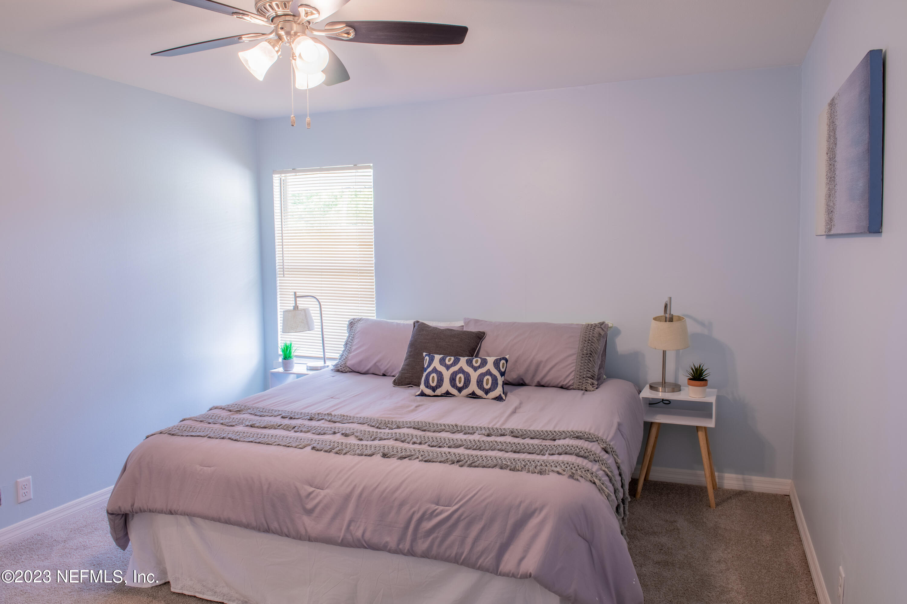6958 Champlain Road Jacksonville, FL 32208 - Photo 16 of 34 a bedroom with a bed and a chandelier