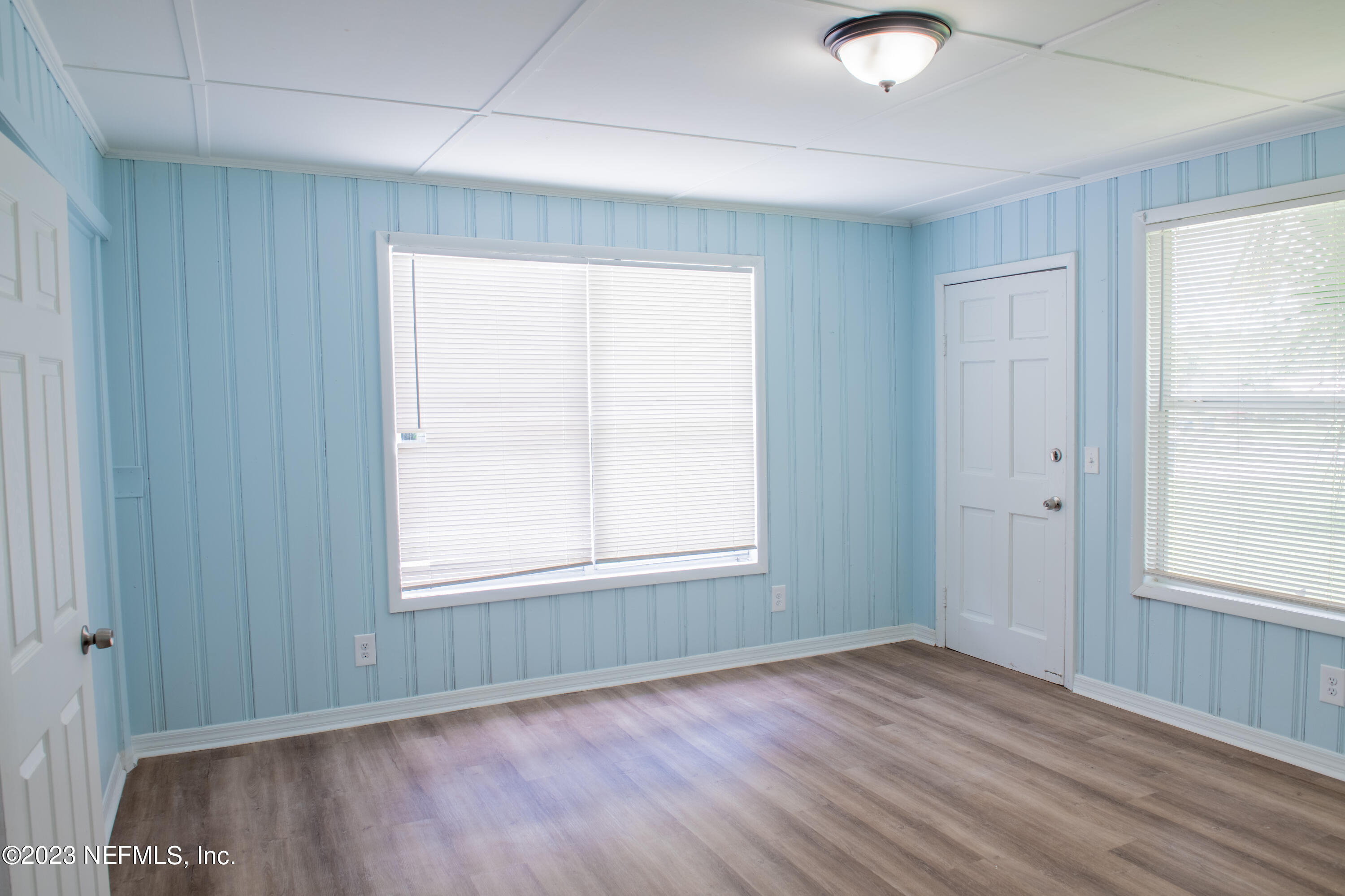 6958 Champlain Road Jacksonville, FL 32208 - Photo 26 of 34 an empty room with wooden floor and windows