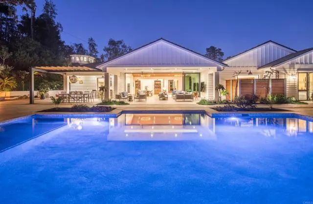 a view of a swimming pool with a table and chairs under an umbrella