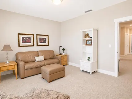 a living room with furniture and wall paintings