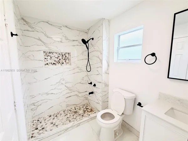a white toilet sitting next to a bathroom sink