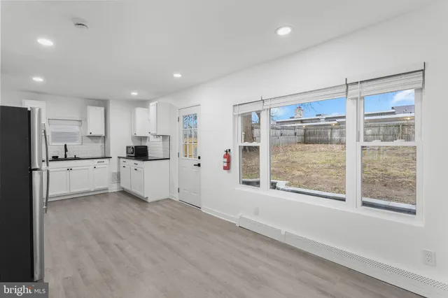 a view of a kitchen with stainless steel appliances refrigerator and window