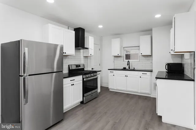 a kitchen with stainless steel appliances a refrigerator stove microwave and sink