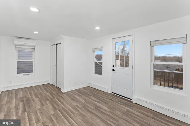 a view of empty room with wooden floor