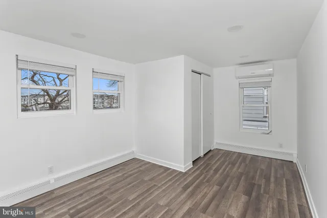 a view of a hallway with wooden floor and closet
