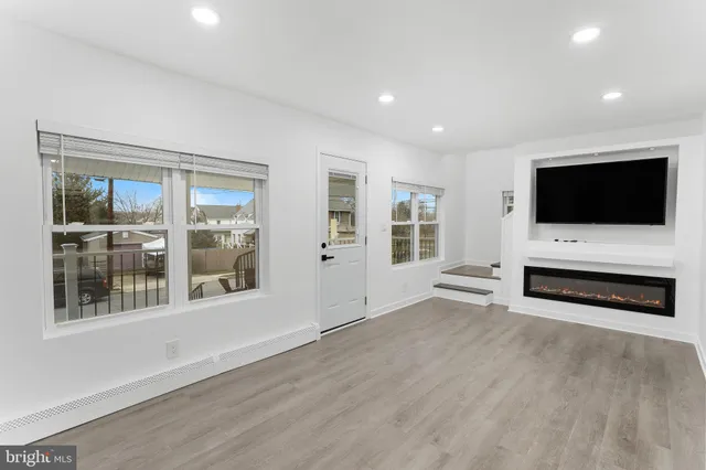 a view of a livingroom with furniture flat screen tv and windows