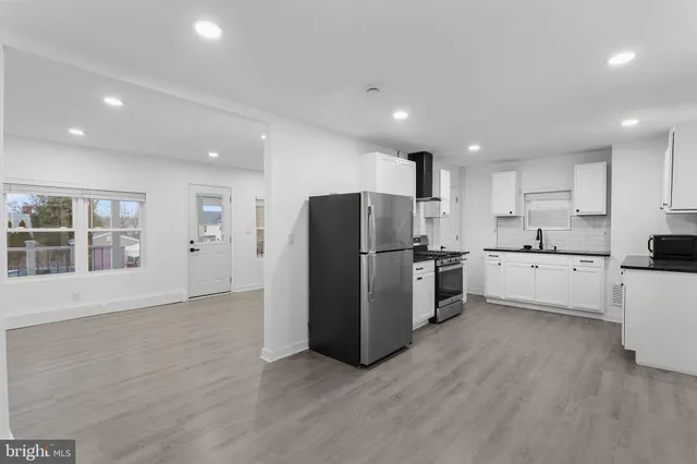 a large kitchen with stainless steel appliances a refrigerator and a stove top oven
