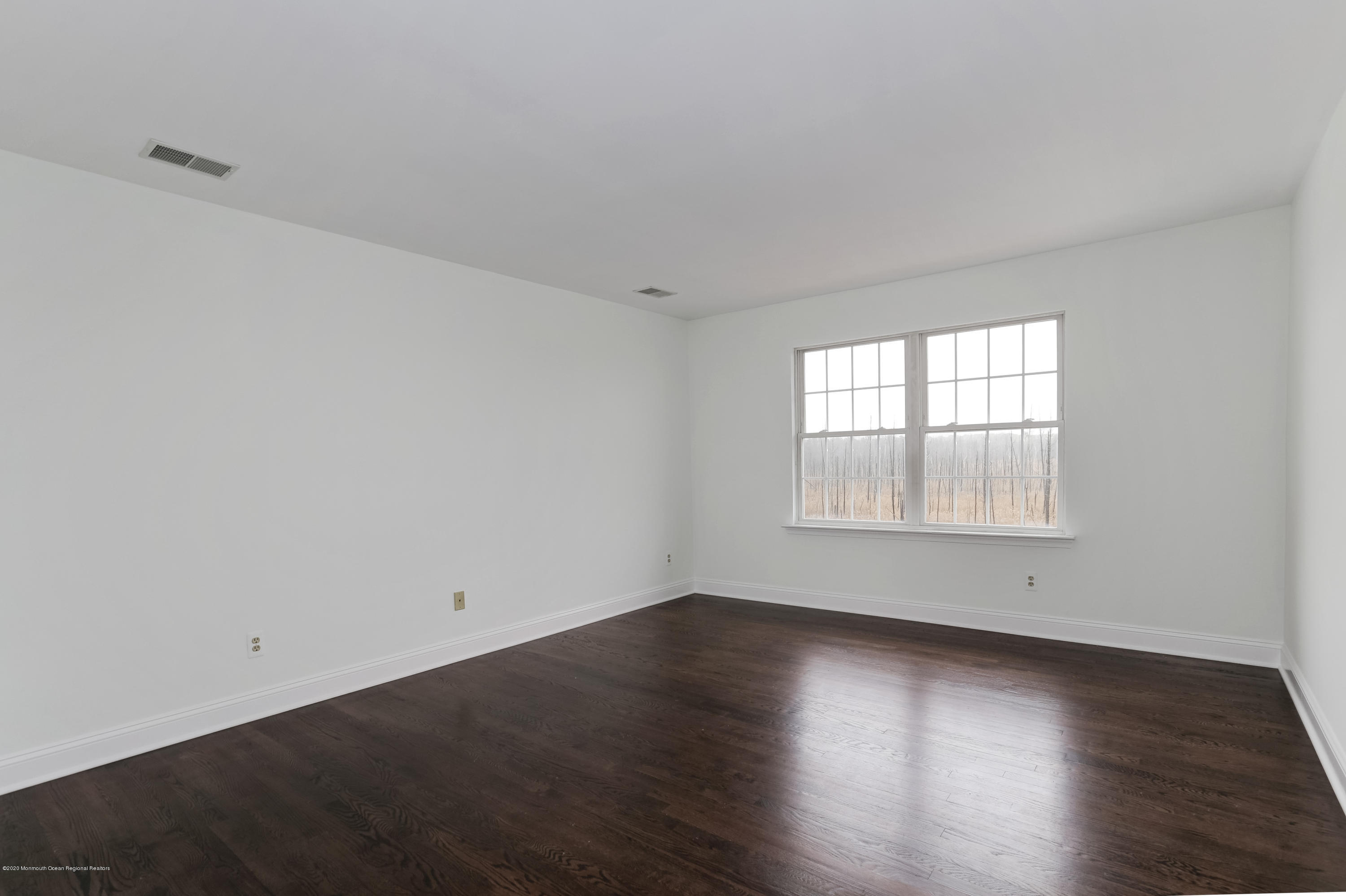 153 Royal Drive Brick, NJ 08723 - Photo 26 of 32 an empty room with wooden floor and windows