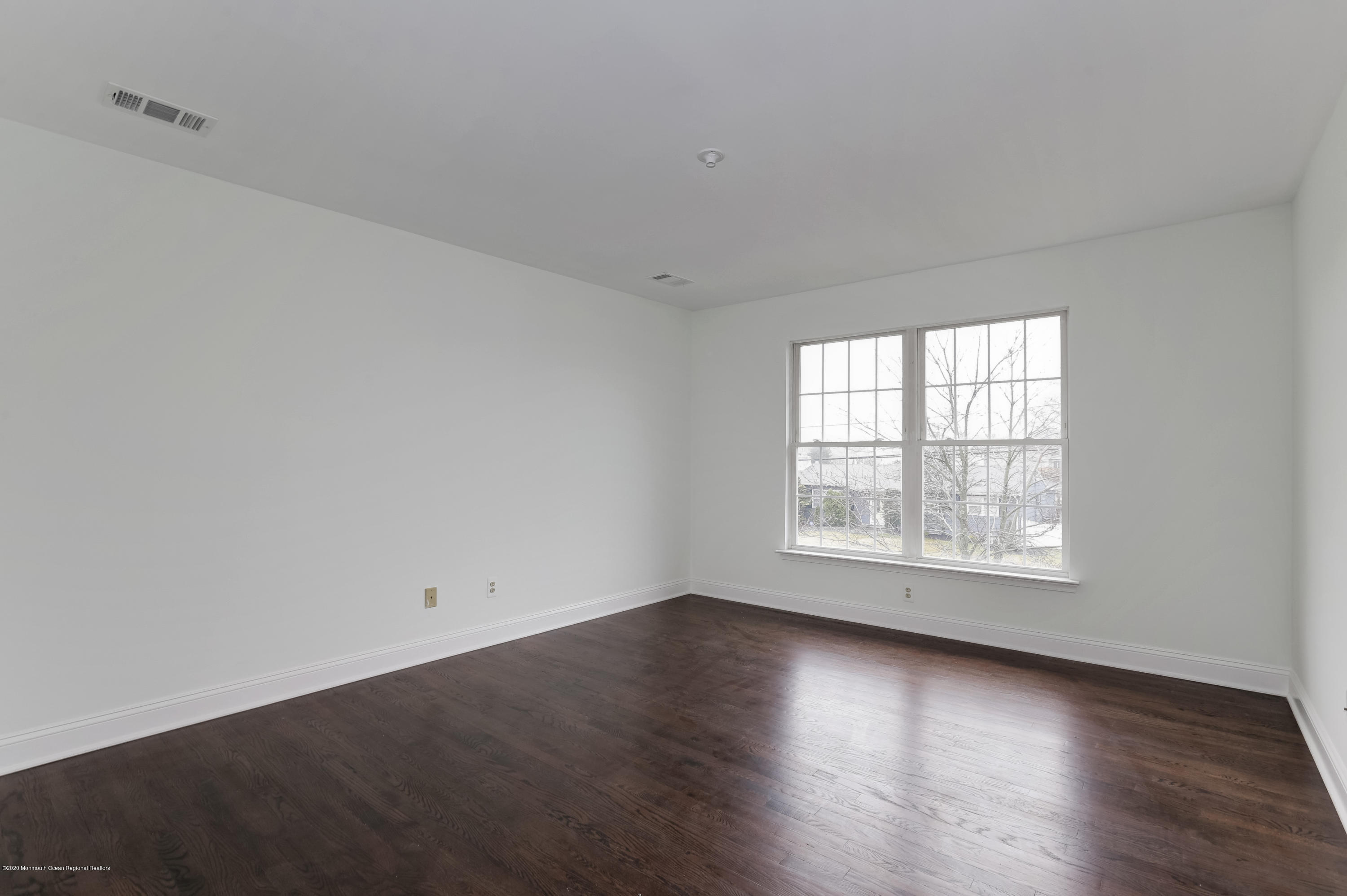153 Royal Drive Brick, NJ 08723 - Photo 31 of 32 an empty room with wooden floor and windows