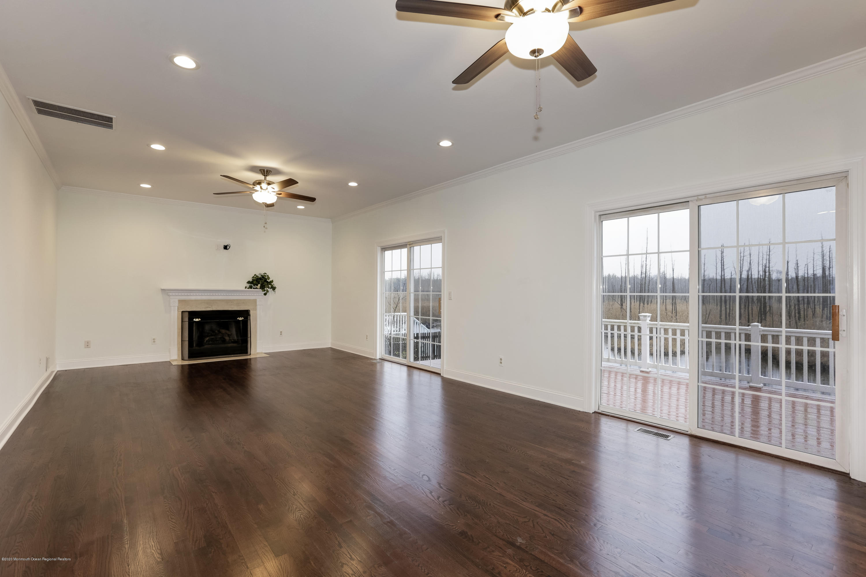 153 Royal Drive Brick, NJ 08723 - Photo 4 of 32 a view of an empty room with wooden floor fireplace and a window