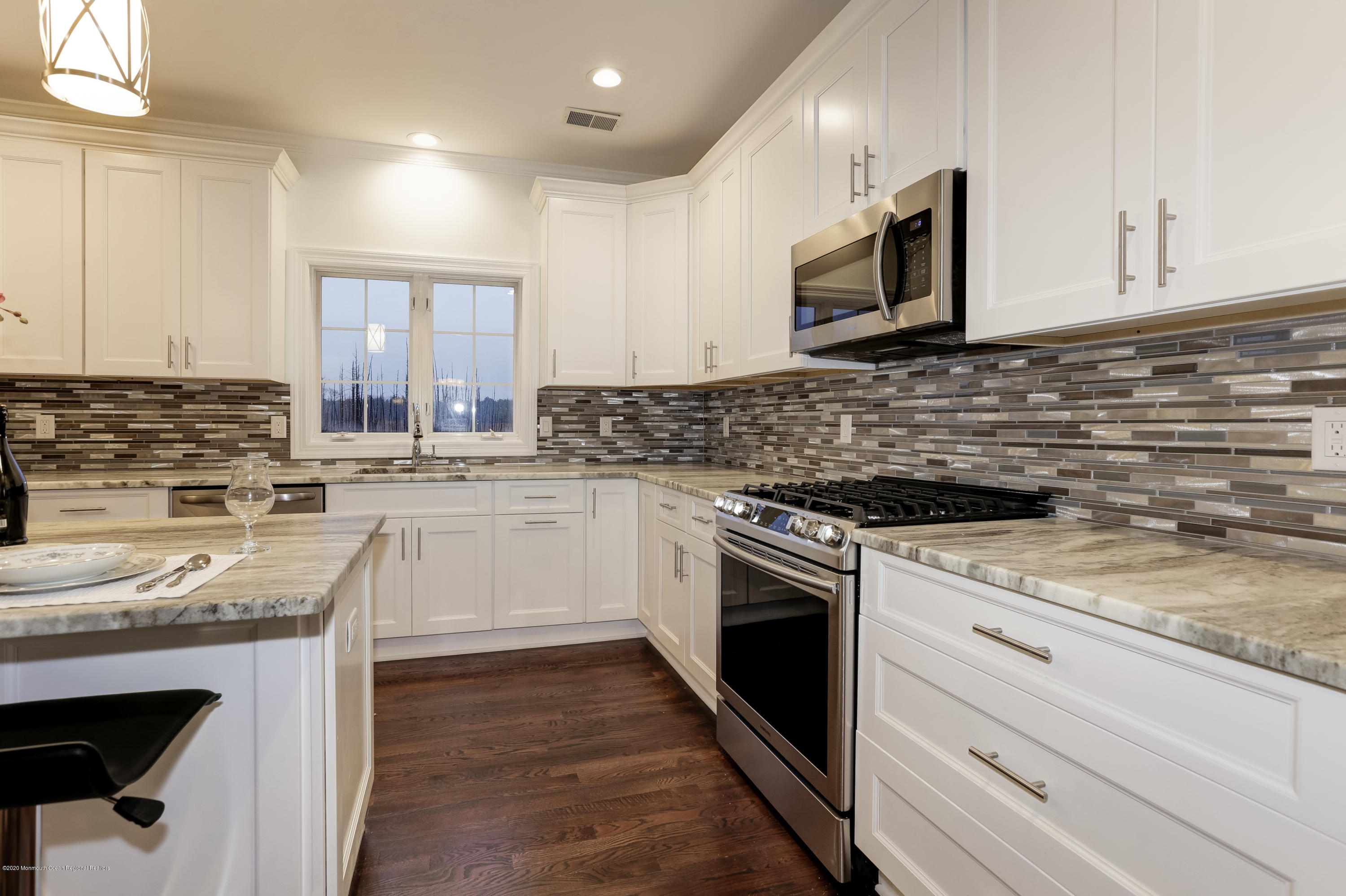 153 Royal Drive Brick, NJ 08723 - Photo 9 of 32 a kitchen with granite countertop a sink stainless steel appliances and white cabinets