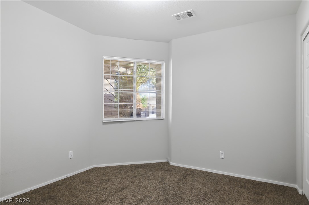 5100 Rancher Avenue Las Vegas, NV 89108 - Photo 16 of 26 A well-lit bedroom offering a warm, inviting atmosphere with soft carpet flooring.