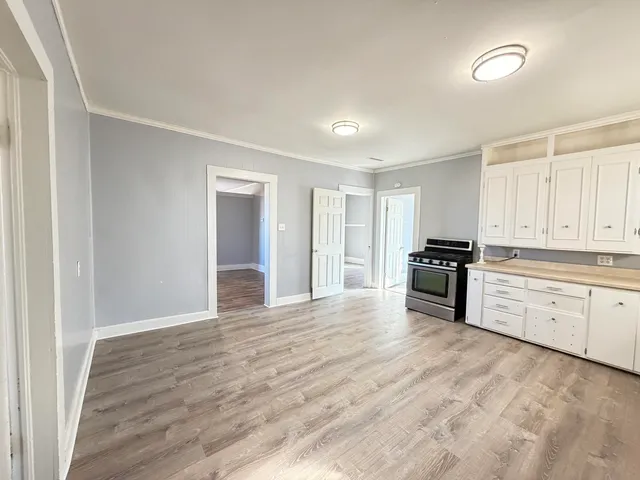 a kitchen with granite countertop a stove and cabinets