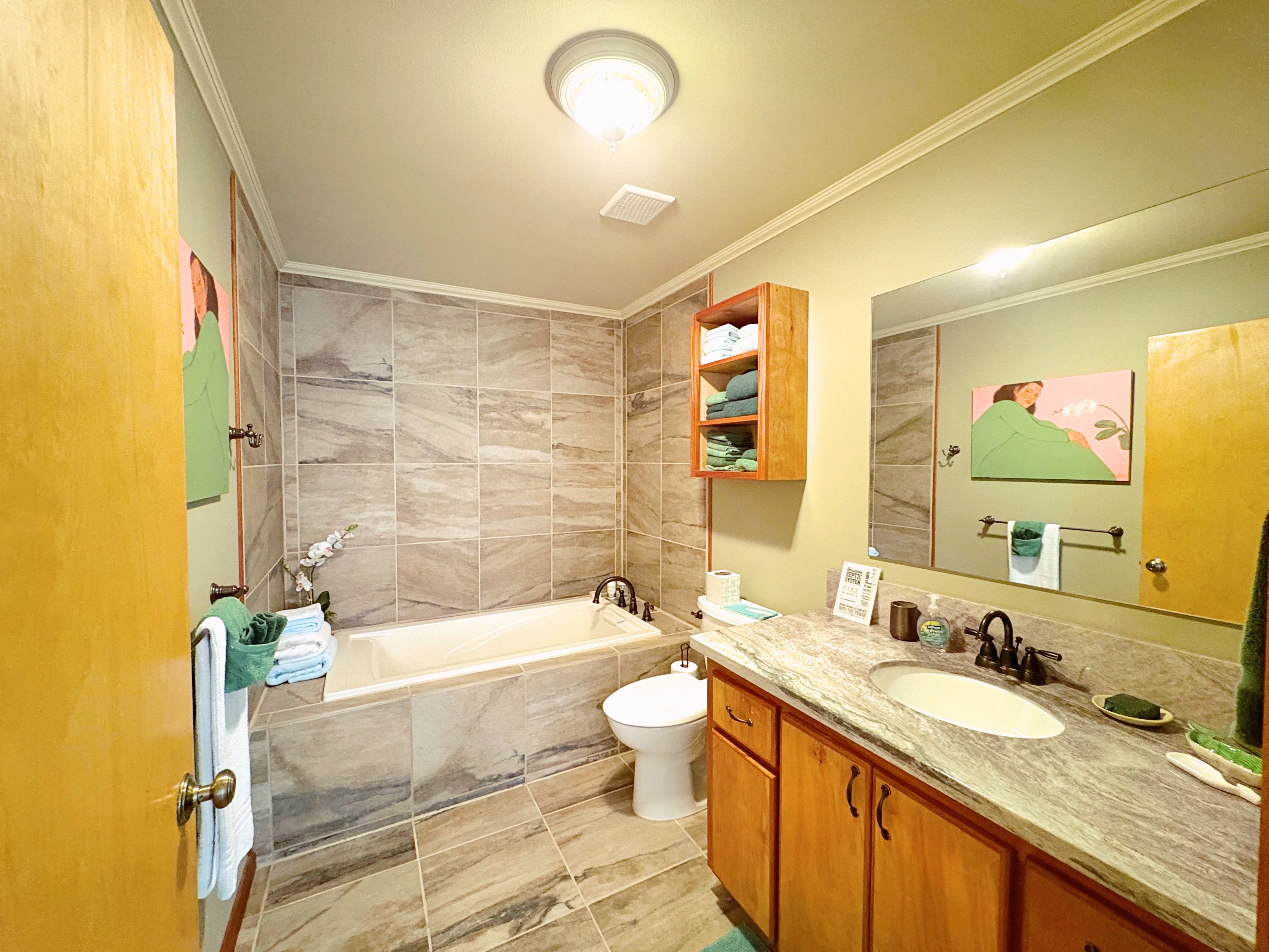 19-4218 Kawailehua Road Volcano, HI 96785 - Photo 12 of 30 a bathroom with a granite countertop sink toilet mirror and bathtub
